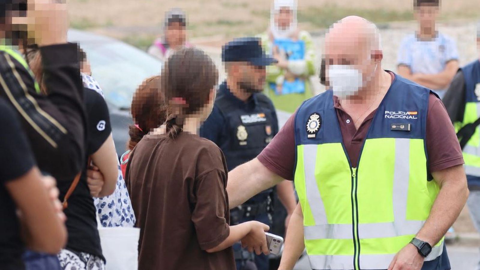 Un agente de policía habla con la gente durante el traslado