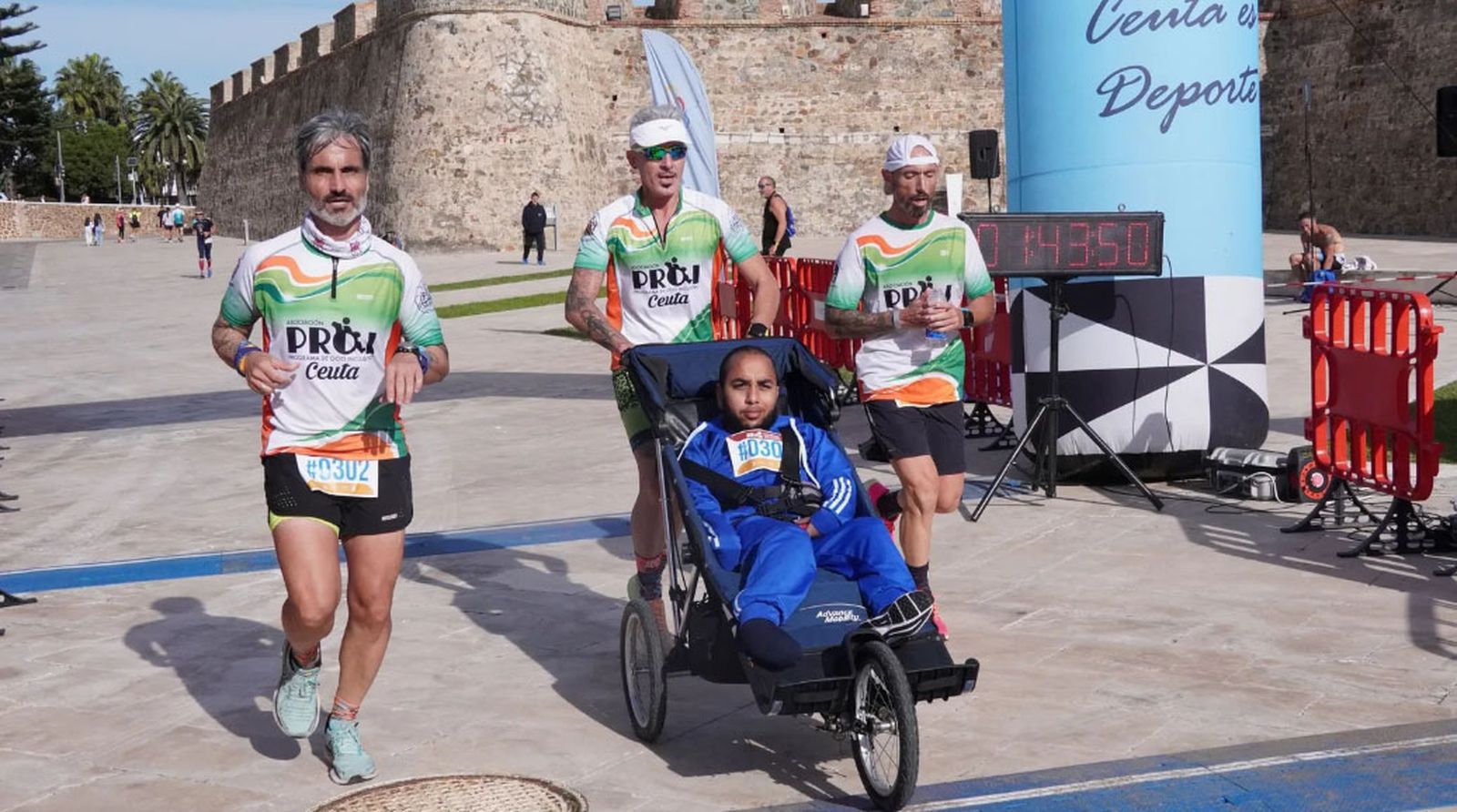 Corredor de PROI con su impulsor voluntario durante la Media Maratón de este domingo