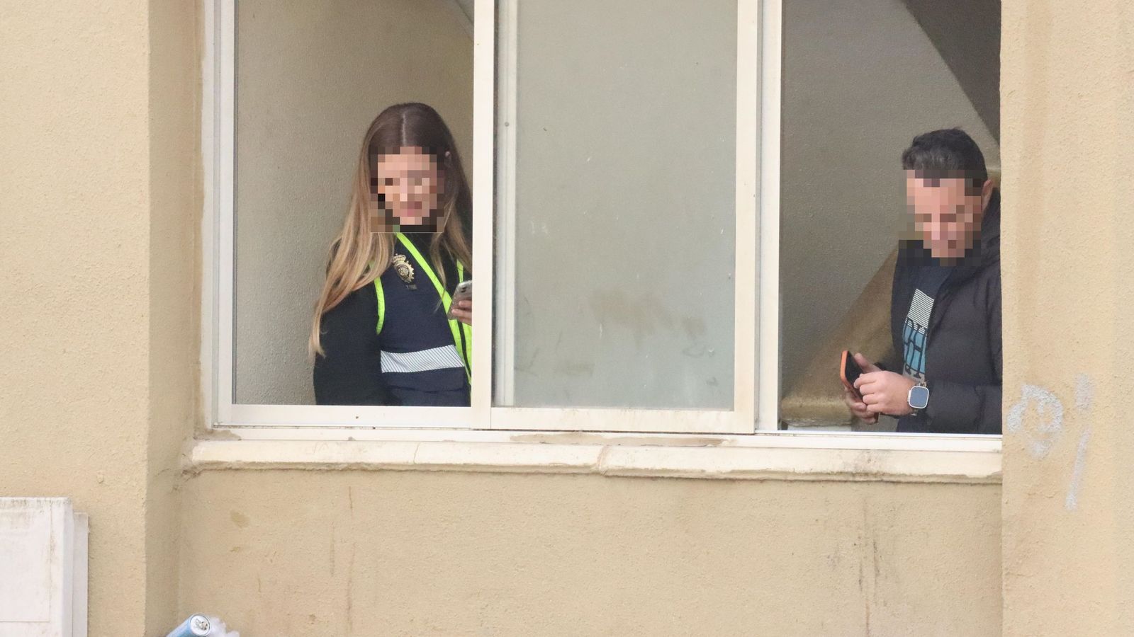 Un hombre, en estado crítico tras precipitarse desde un cuarto piso en Erquicia. Dos agentes inspeccionan la ventana por la que se ha precipitado el hombre