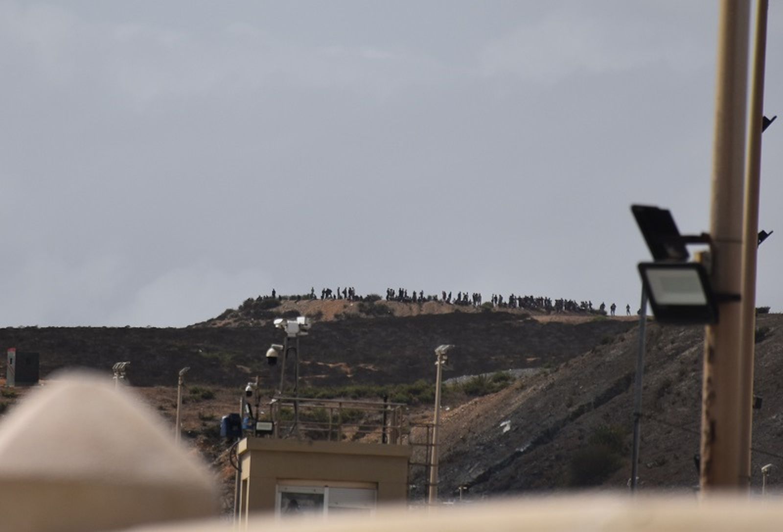 En la imagen, tomada desde la zona española, se observa la hilera de personas en territorio marroquí que esperaba saltar la valla fronteriza. / FOTO G.S.