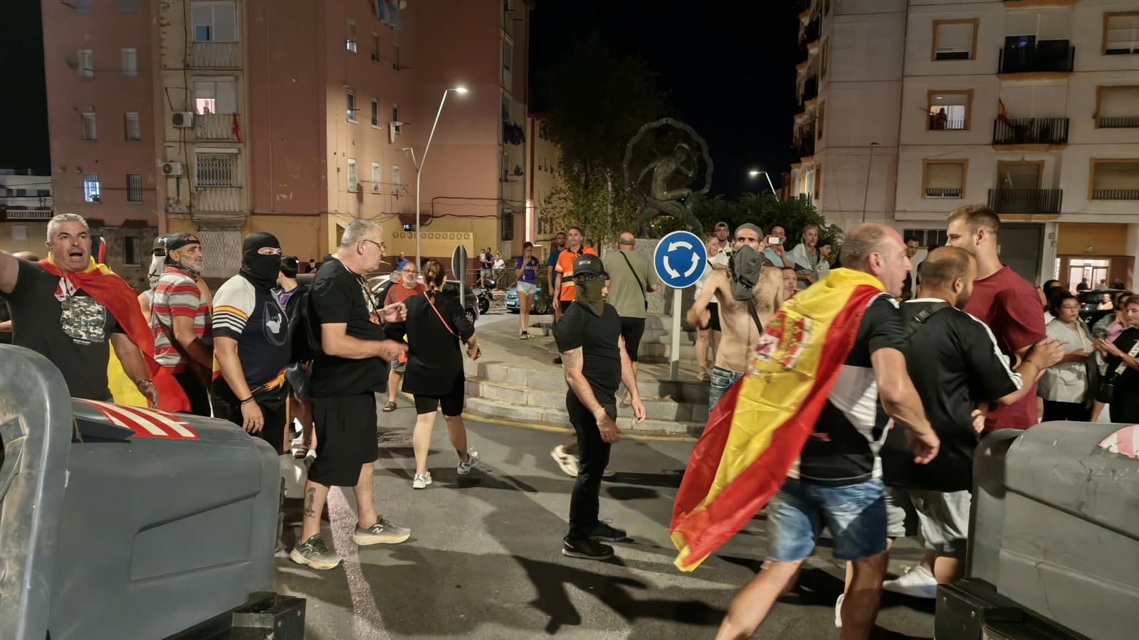 Ciudadanos se manifiestan en las barriadas de la ciudad contra la gestión de la crisis y tiran contenedores al suelo