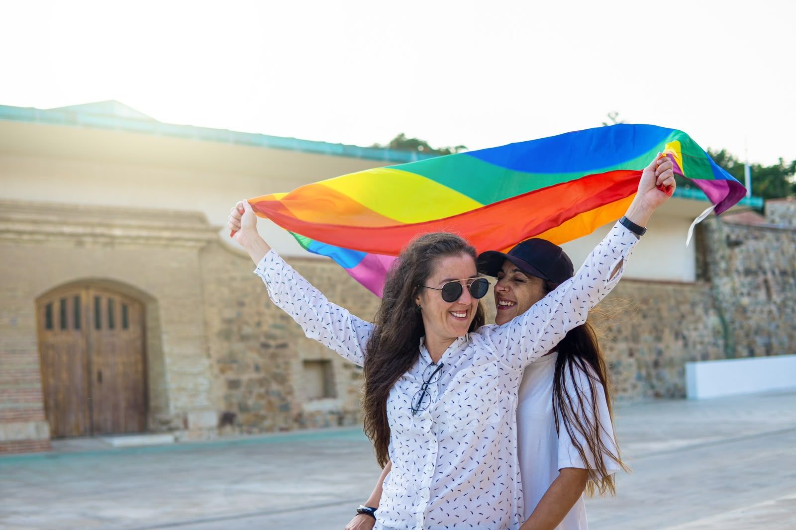 Rocío Escamilla y Jennifer García posan con la bandera del Orgullo LGTBIQ+ en las Murallas Reales