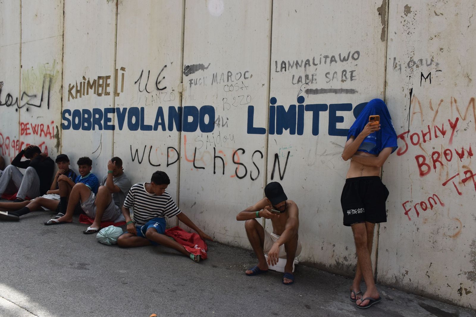Migrantes en las inmediaciones del CETI a la espera de ingresar en las instalaciones