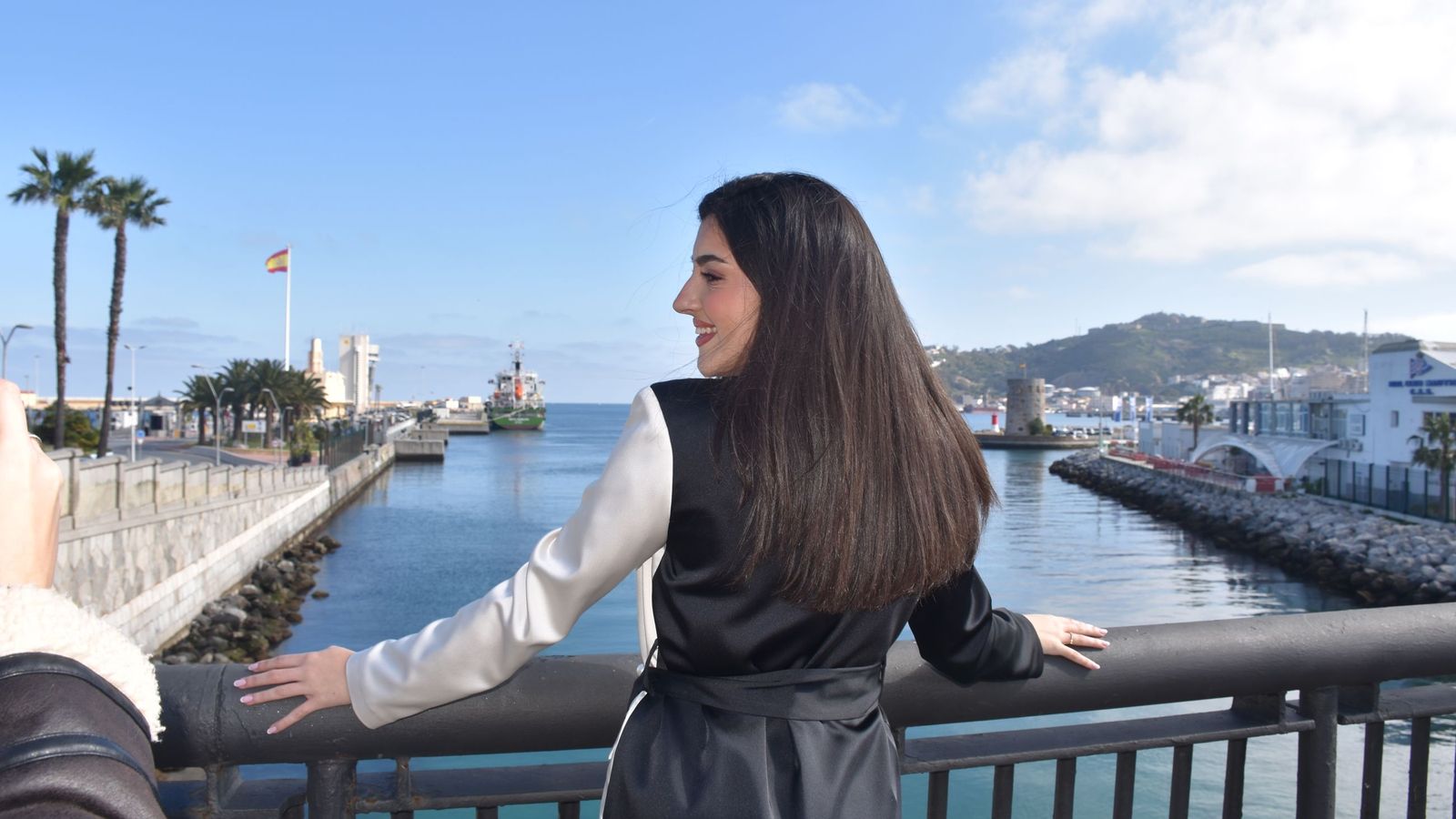 Alejandra Ortega posando con el Muelle España y el Monte Hacho como escenarios