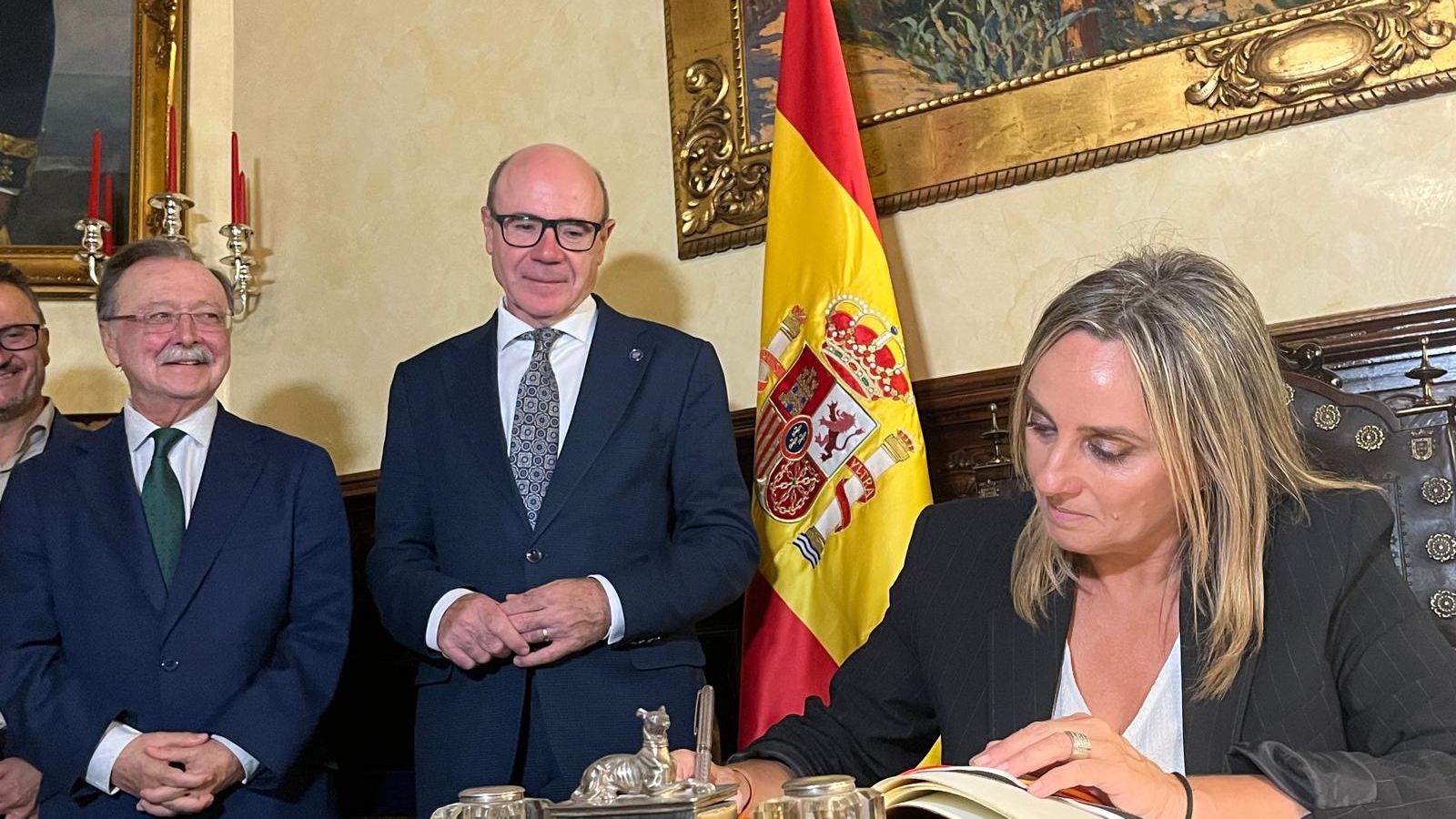 La alcaldesa de Granada firma en el Libro de Honor de la Ciudad bajo un cuadro de Mariano Bertuchi