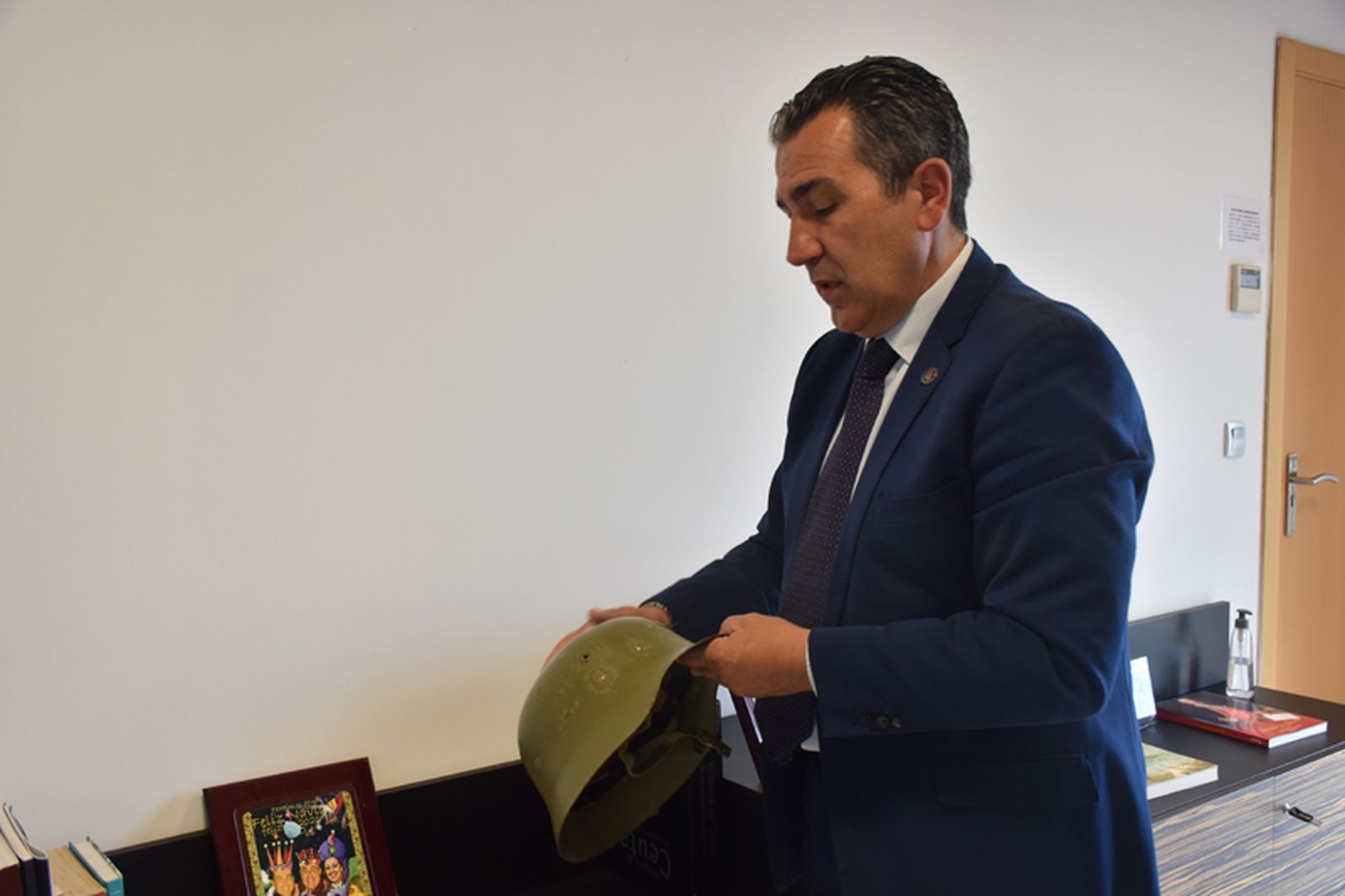 Carlos Rontomé sostiene el que fuera su casco durante su etapa militar. / FOTO G.S.
