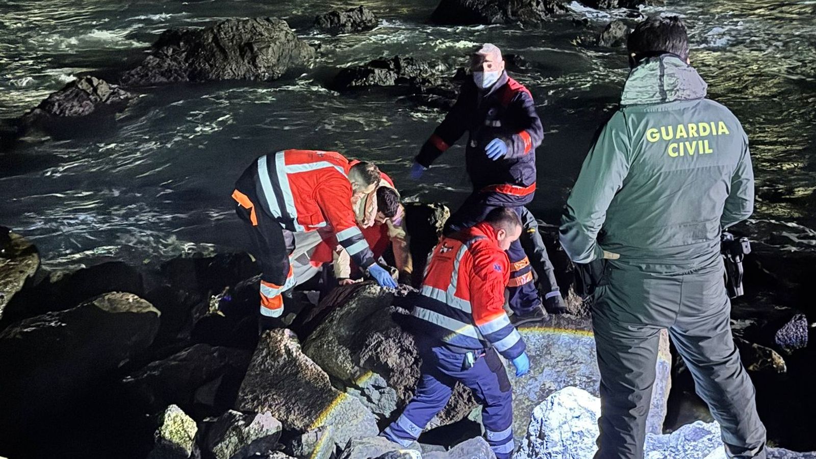Agentes interviniendo en el espigón de Benzú junto a empleados del 061
