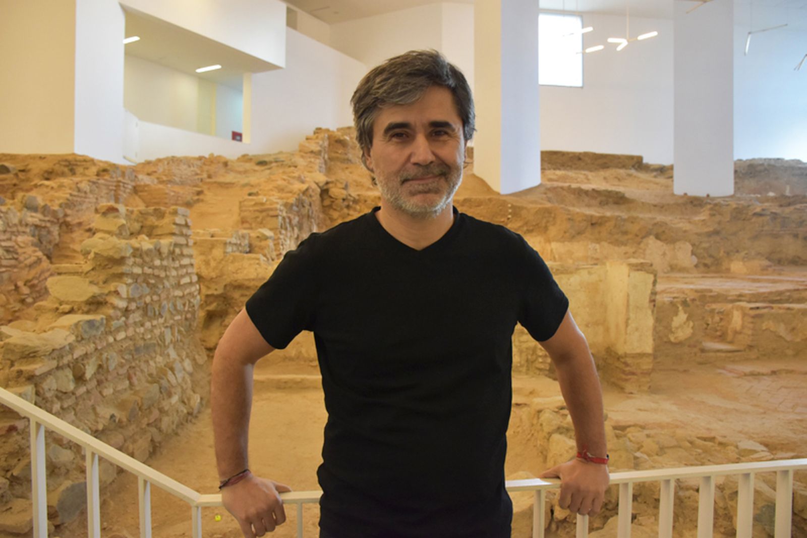 El escritor Pedro Simón junto al yacimiento 'Huerta Rufino', en la biblioteca Adolfo Suárez. / FOTO G.S.