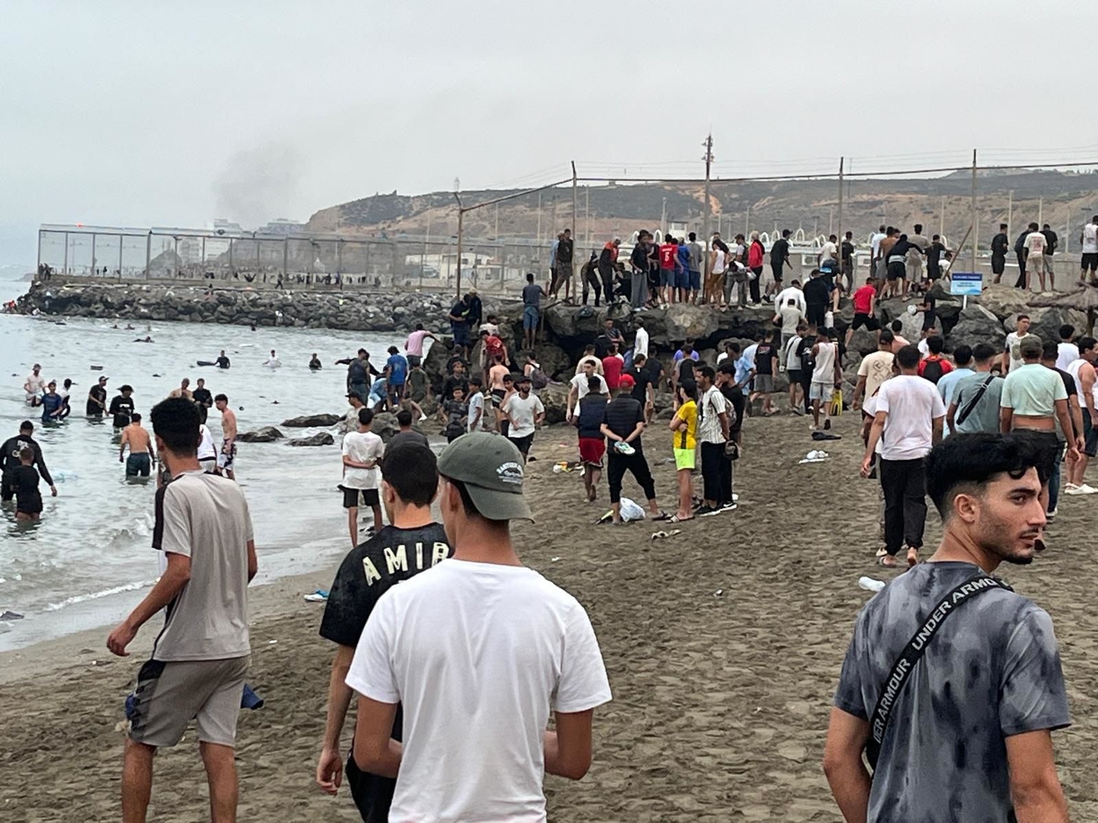 Migrantes reunidos en la playa de El Tarajal