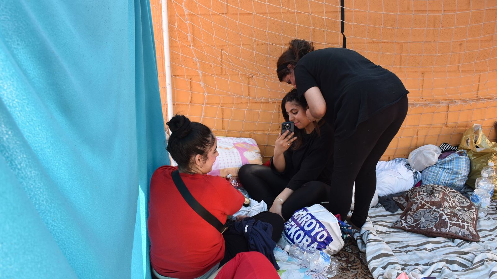 Una chica peina a otra en el campamento de mujeres migrantes en La Reina