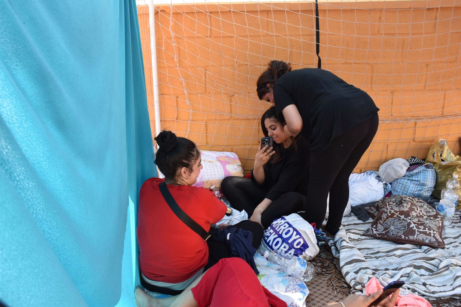 Una chica peina a otra en el campamento de mujeres migrantes en La Reina