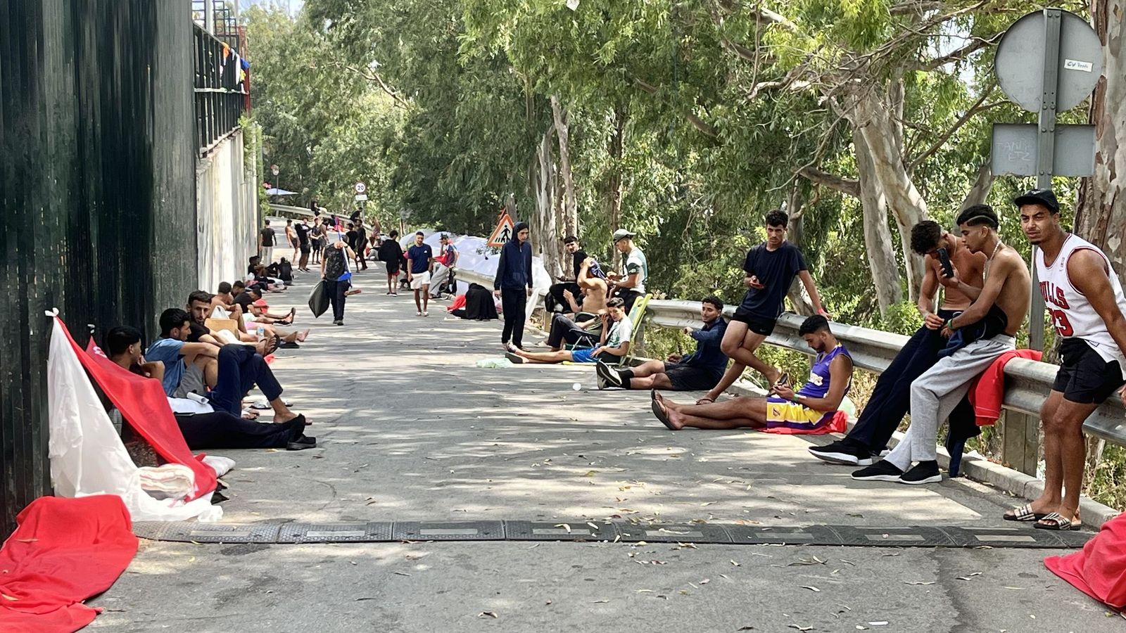 Personas migrantes esperando a las puertas del CETI su ingreso en las instalaciones